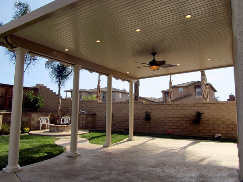 Tall solid patio cover with pillars and fan