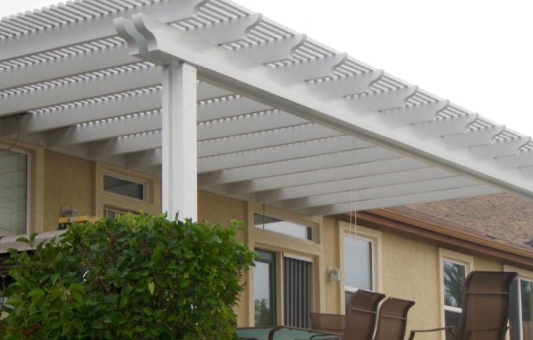 A serene Lattice patio Cover with white pergola and chairs