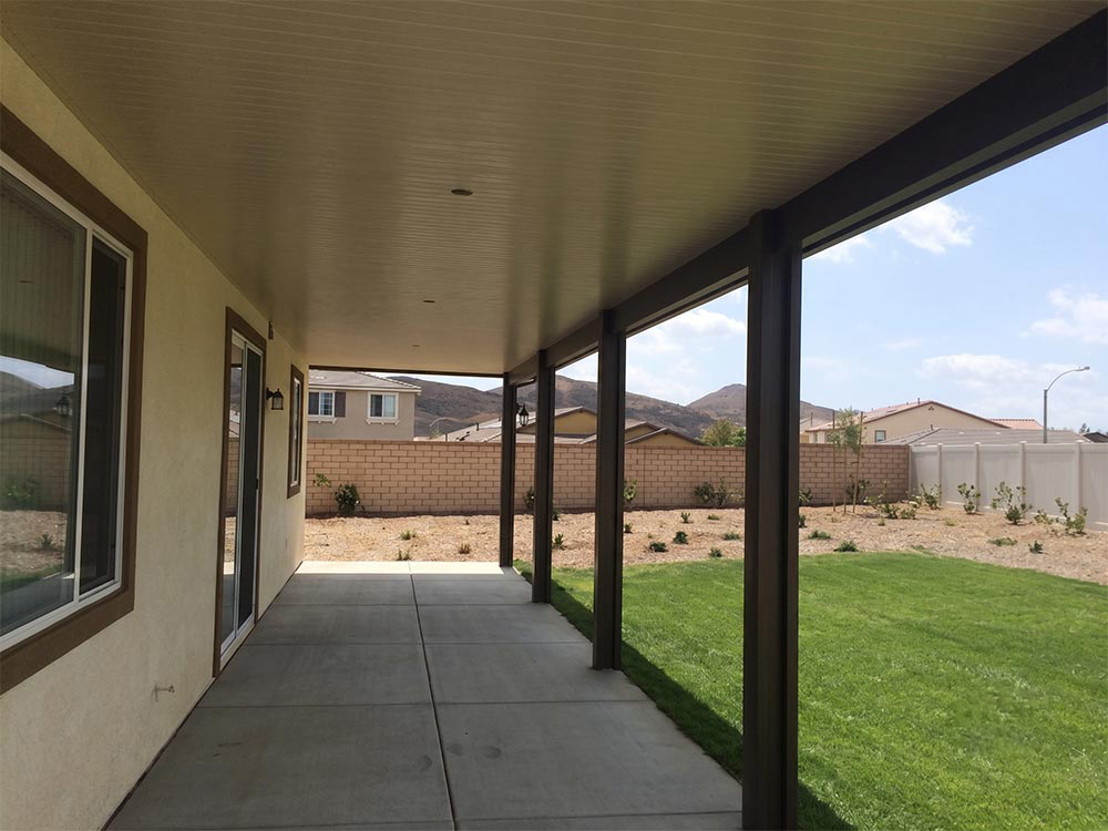 Insulated solid aluminum patio cover with an Almond ceiling and brown trim on a Wildomar, CA home