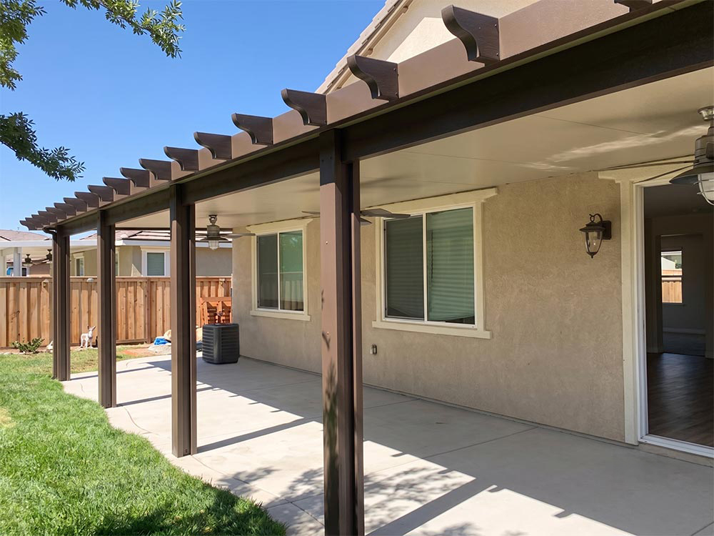Insulated patio cover with Latte ceiling, brown trim, scalloped end tails and two ceiling fans in Wildomar CA