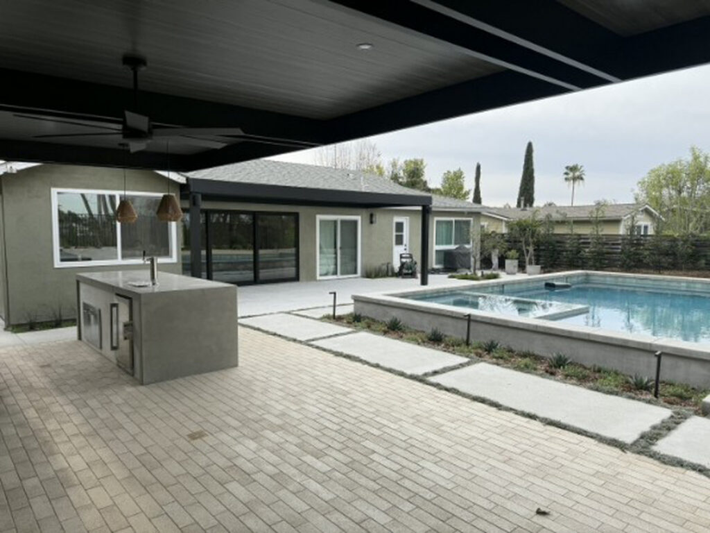Black 4K aluminum patio cover with an outdoor kitchen island beside a pool in Mission Viejo, CA