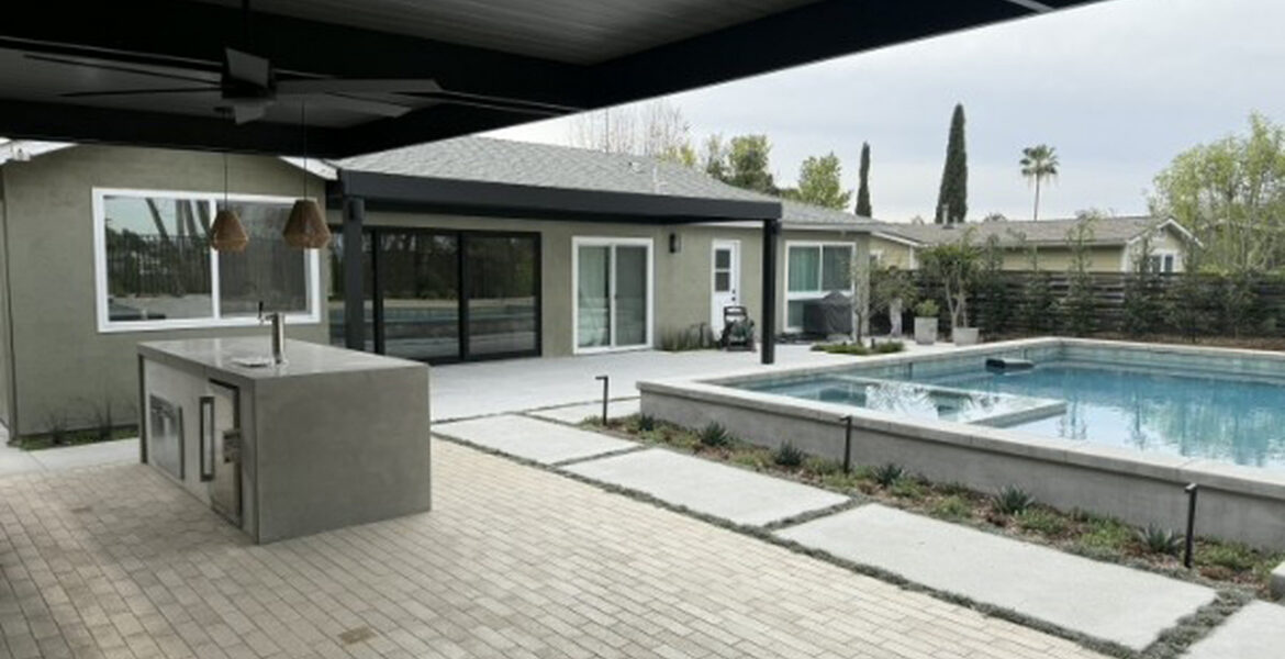 Black 4K aluminum patio cover with an outdoor kitchen island beside a pool in Mission Viejo, CA