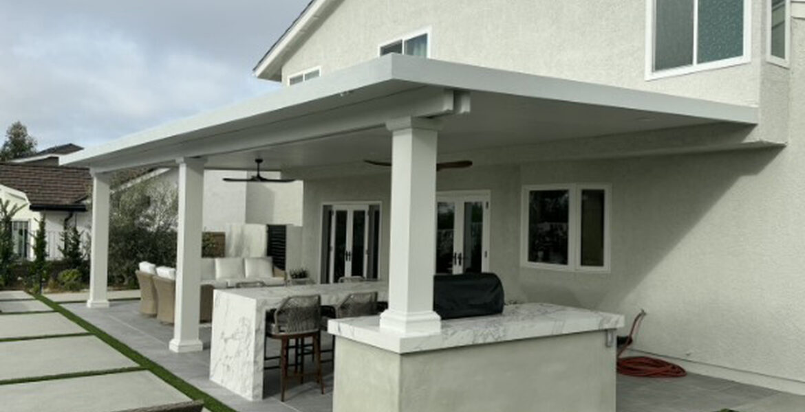 White solid aluminum patio cover with a marble outdoor kitchen bar and putting green in Lake Forest, CA