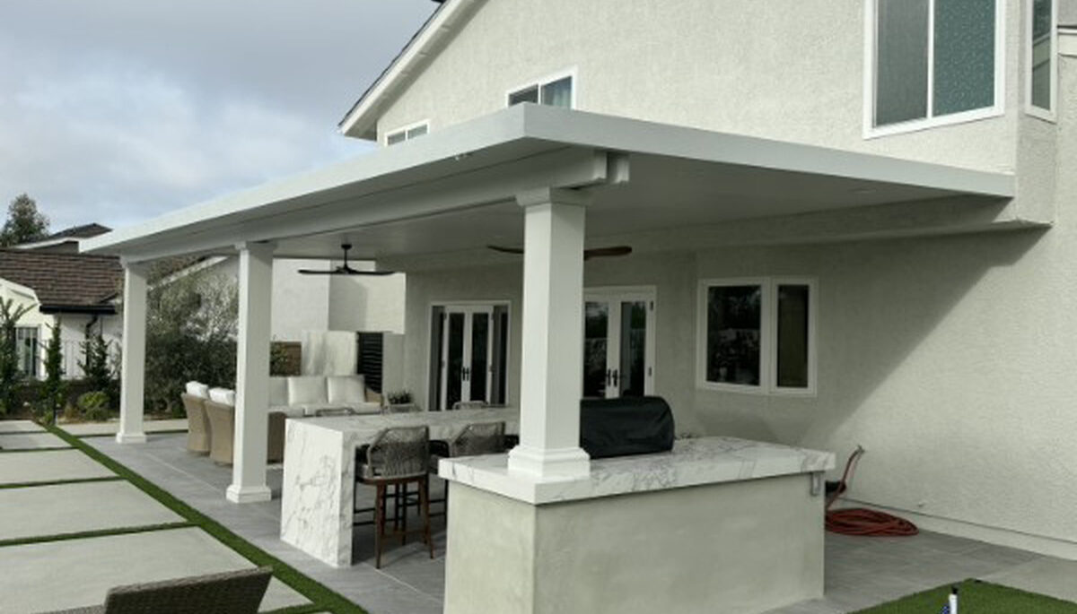 White solid aluminum patio cover with a marble outdoor kitchen bar and putting green in Lake Forest, CA
