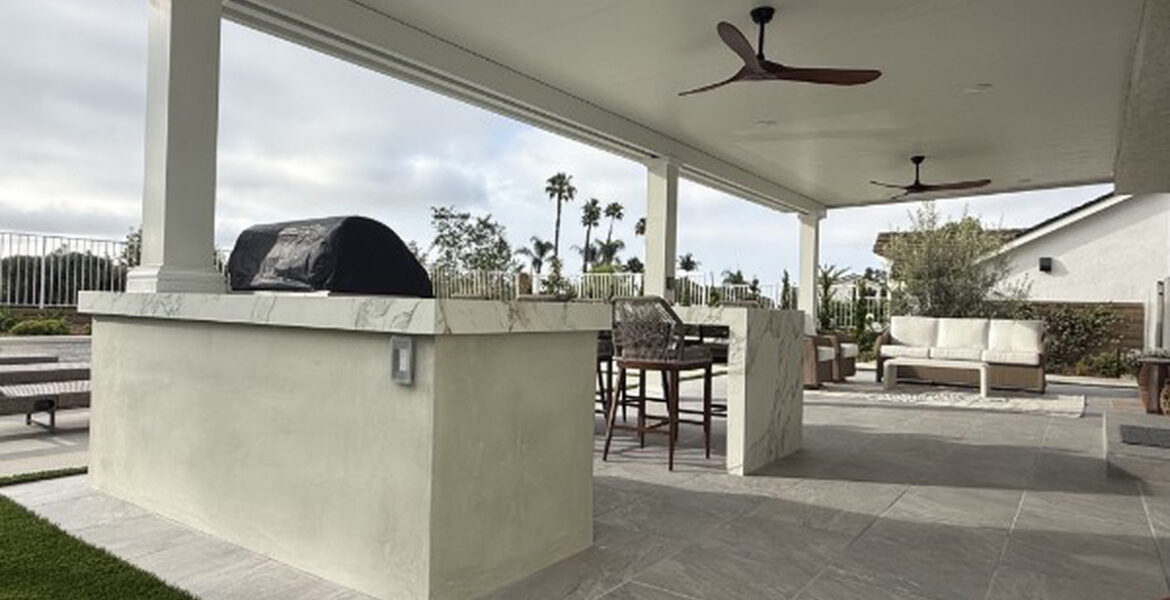 Built-in barbecue island and bar seating under a solid aluminum patio cover in Lake Forest, CA