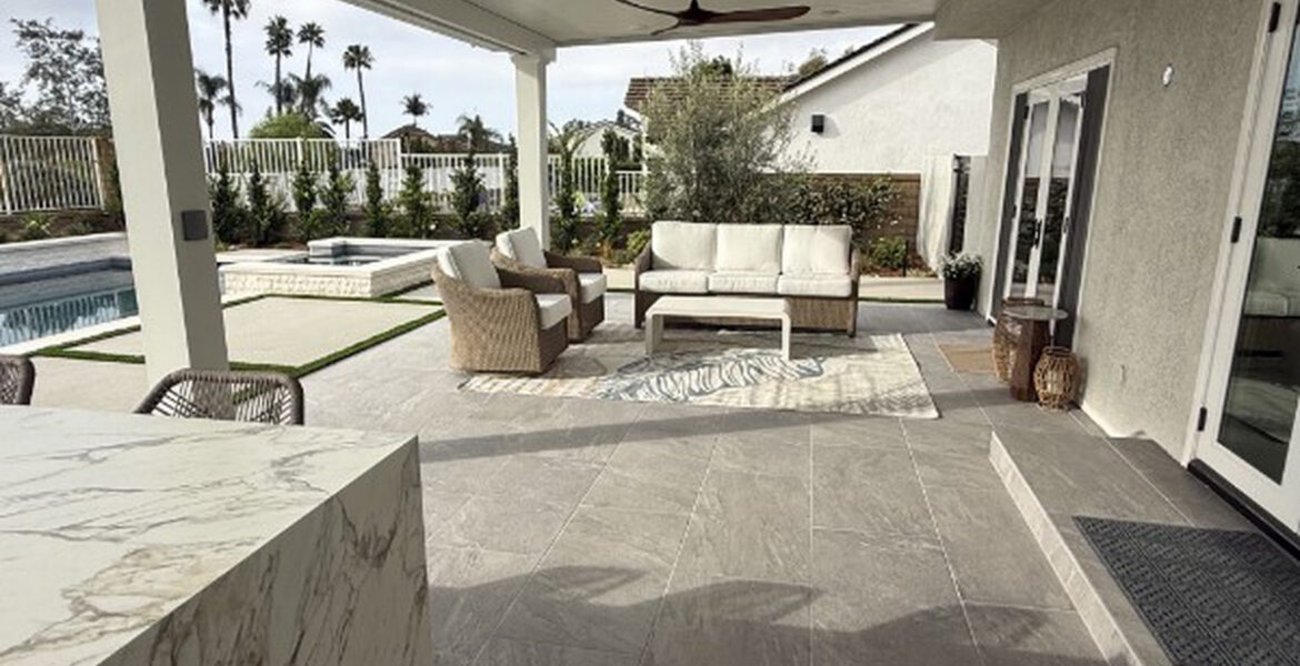 Covered outdoor lounge and marble island beneath a solid aluminum patio cover in Lake Forest, CA
