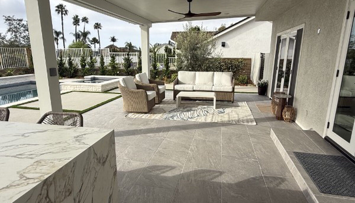 Covered outdoor lounge and marble island beneath a solid aluminum patio cover in Lake Forest, CA