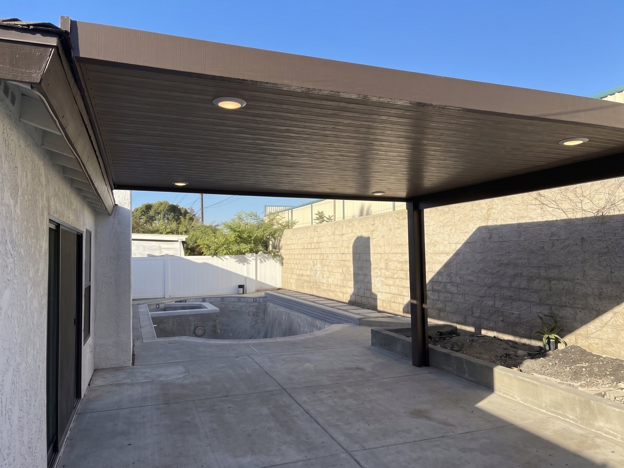 Newly installed solid aluminum patio cover with recessed lights over a Corona patio.